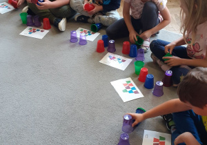 Dzieci układają wieże z kubków wg wzoru