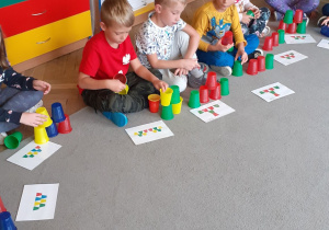 Dzieci z gr. V podczas układania kolorowych kubeczków