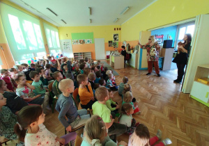 Przedszkolaki z zaciekawieniem patrzą na panią Ulę i jej barwne rekwizyty.