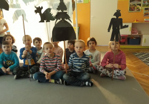Dzieci z gr. IV siedzą na dywanie z kukiełkami z przedstawienia