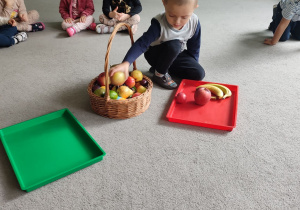 Ihor wybiera z koszyczka jabłka