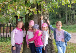 Dziewczynki przytulają się do drzewa