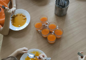 Dzieci jedzą pomarańczowy obiad